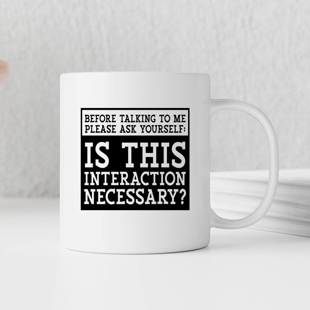 White ceramic coffee mug with black quote: “Is this interaction necessary?”