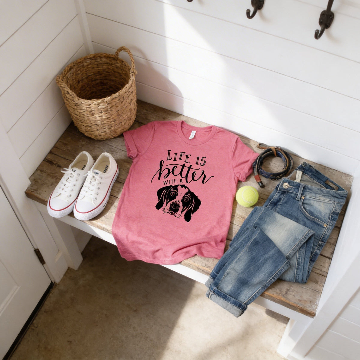 Pink dog mom T-shirt laid flat with “Life is better with” text and black dog graphic