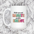 White ceramic coffee mug with “Wake up and RADIATE positive ENERGY” quote