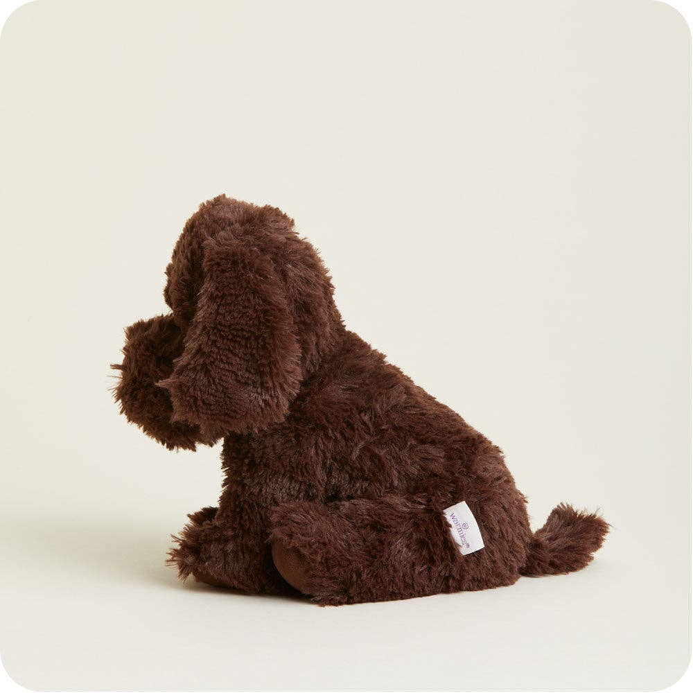 Chocolate brown plush labrador dog lying on its side with a fabric tag