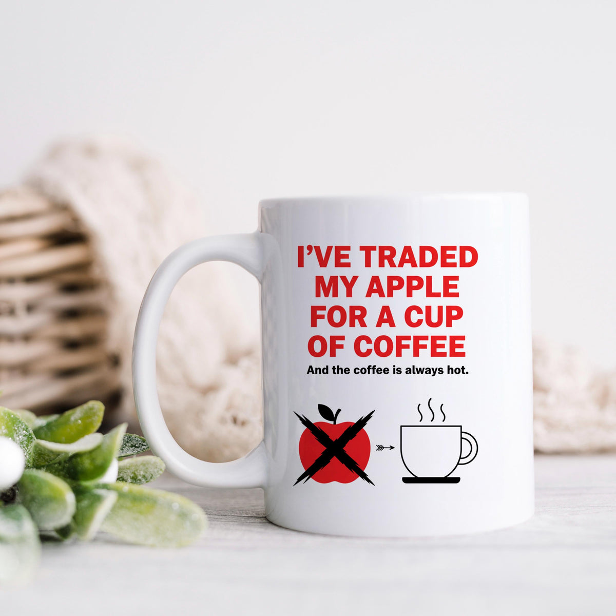 White ceramic coffee mug with red slogan and crossed apple icon on the front