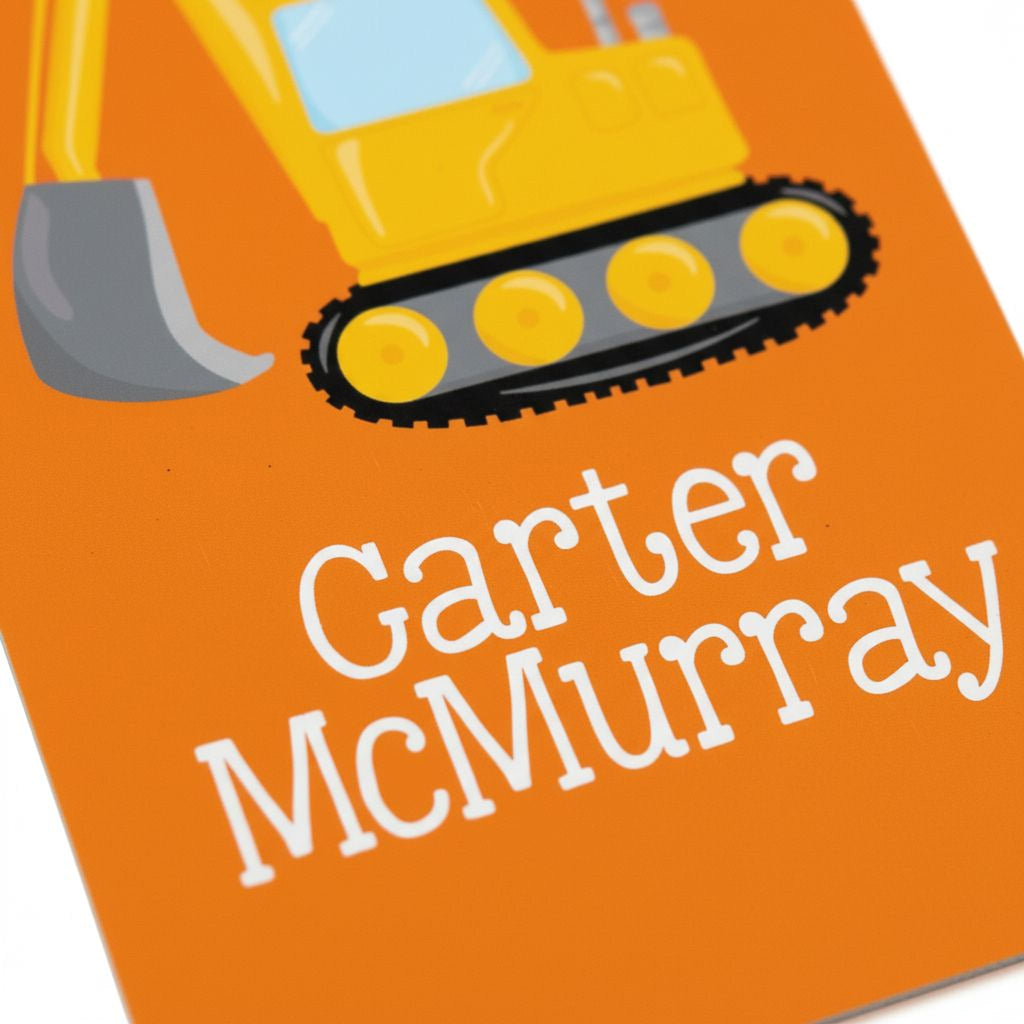 Orange rectangle name tag close-up with backhoe illustration and white script Carter McMurray
