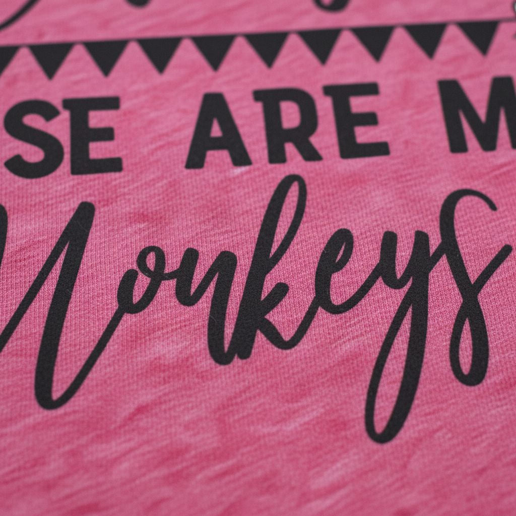 Close-up of black text and monkey quote on pink T-shirt