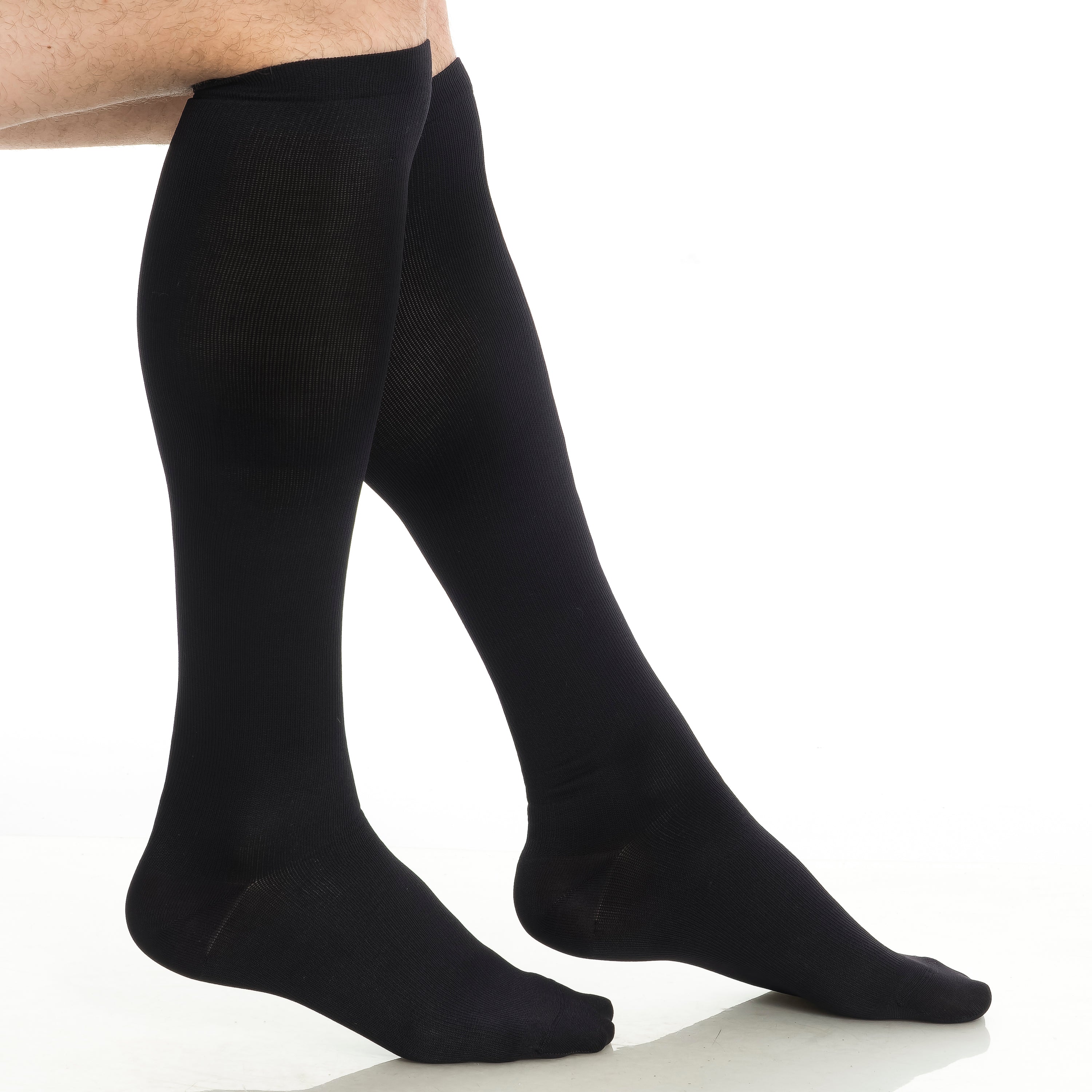 Black knee-high compression socks worn by an adult, close-up
