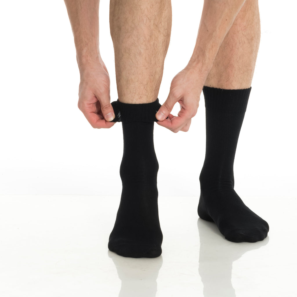 Black bamboo diabetic crew socks on legs, hands adjusting ribbed top cuff.