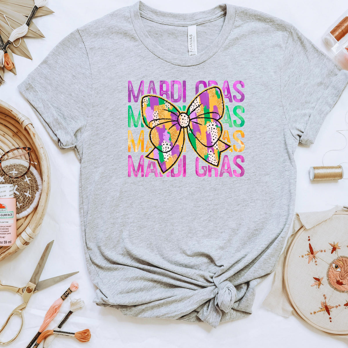 Heather gray short-sleeve t-shirt with Mardi Gras bow and colorful stacked text graphic