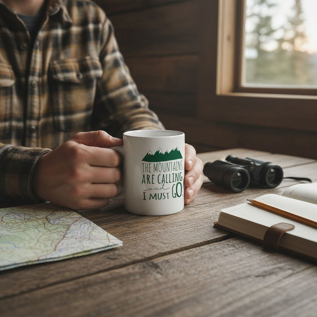 Person holding white ceramic mug with green mountain quote
