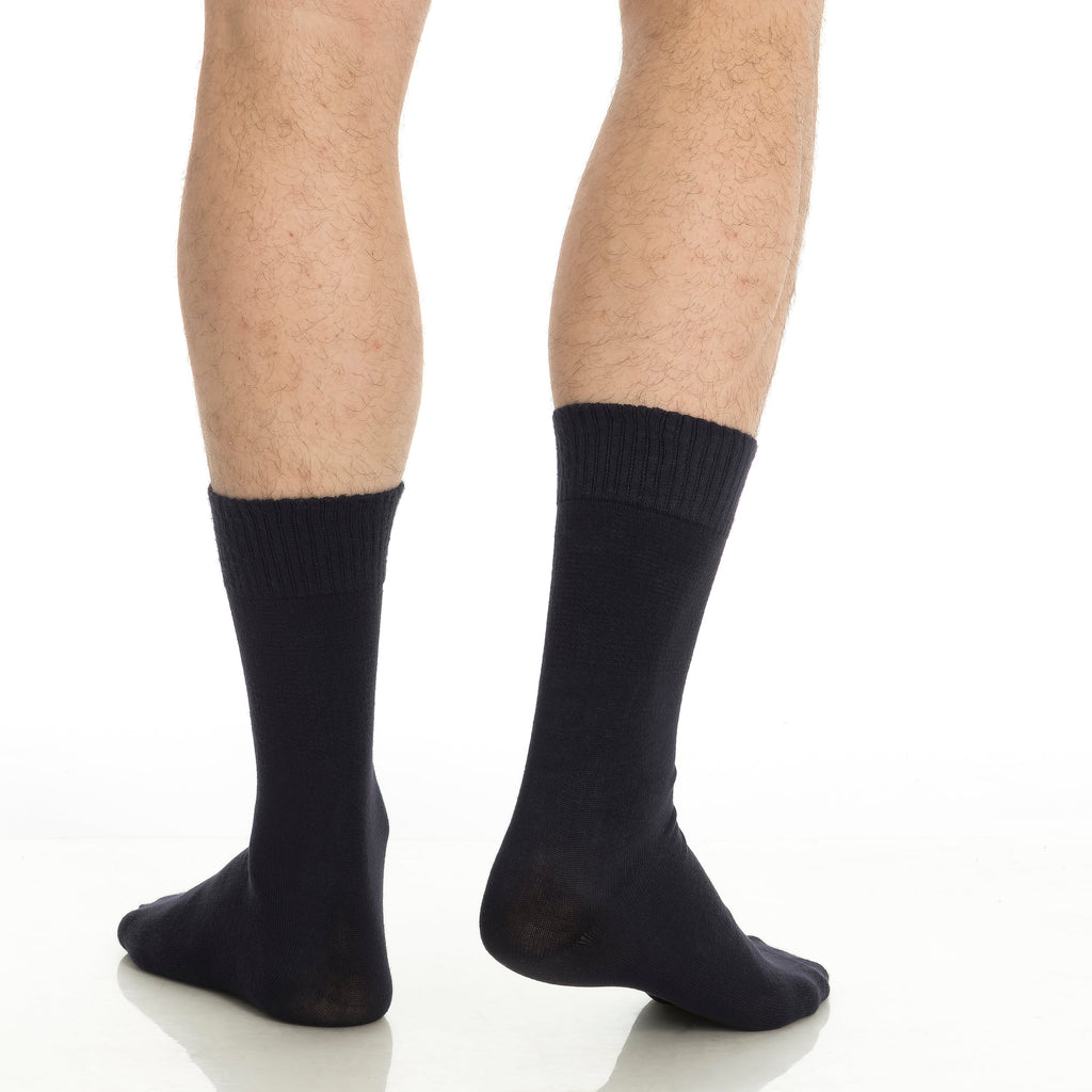Black crew socks on feet, ribbed mid-calf cuffs and seamless toe