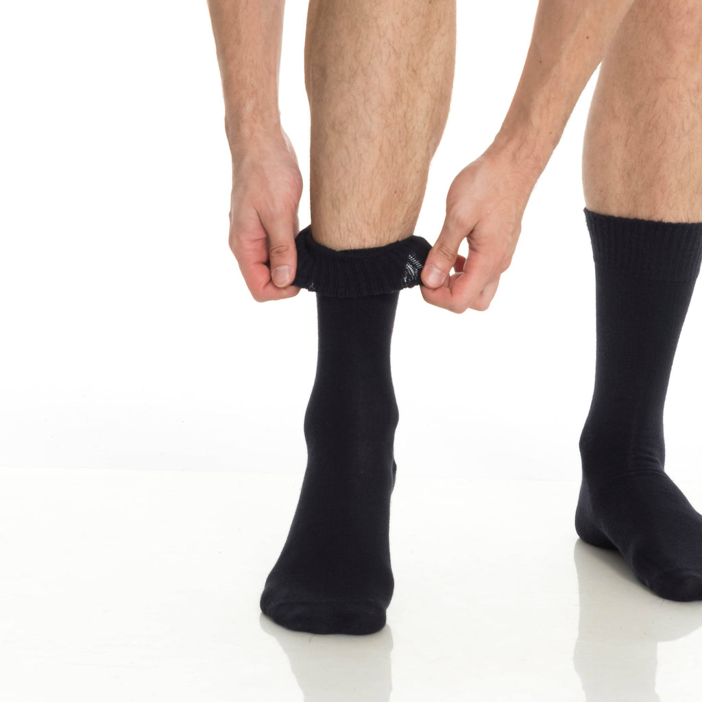 Black crew socks being adjusted, elastic ribbed cuff and cushioned heel.
