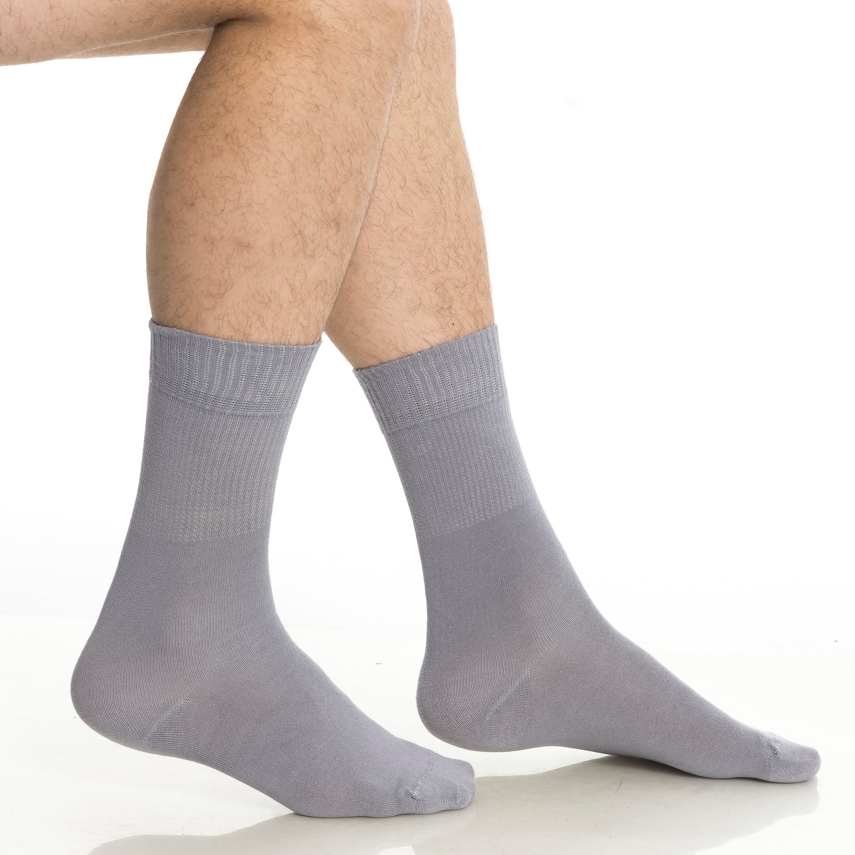 Light gray crew socks on feet, ribbed knit and cushioned sole