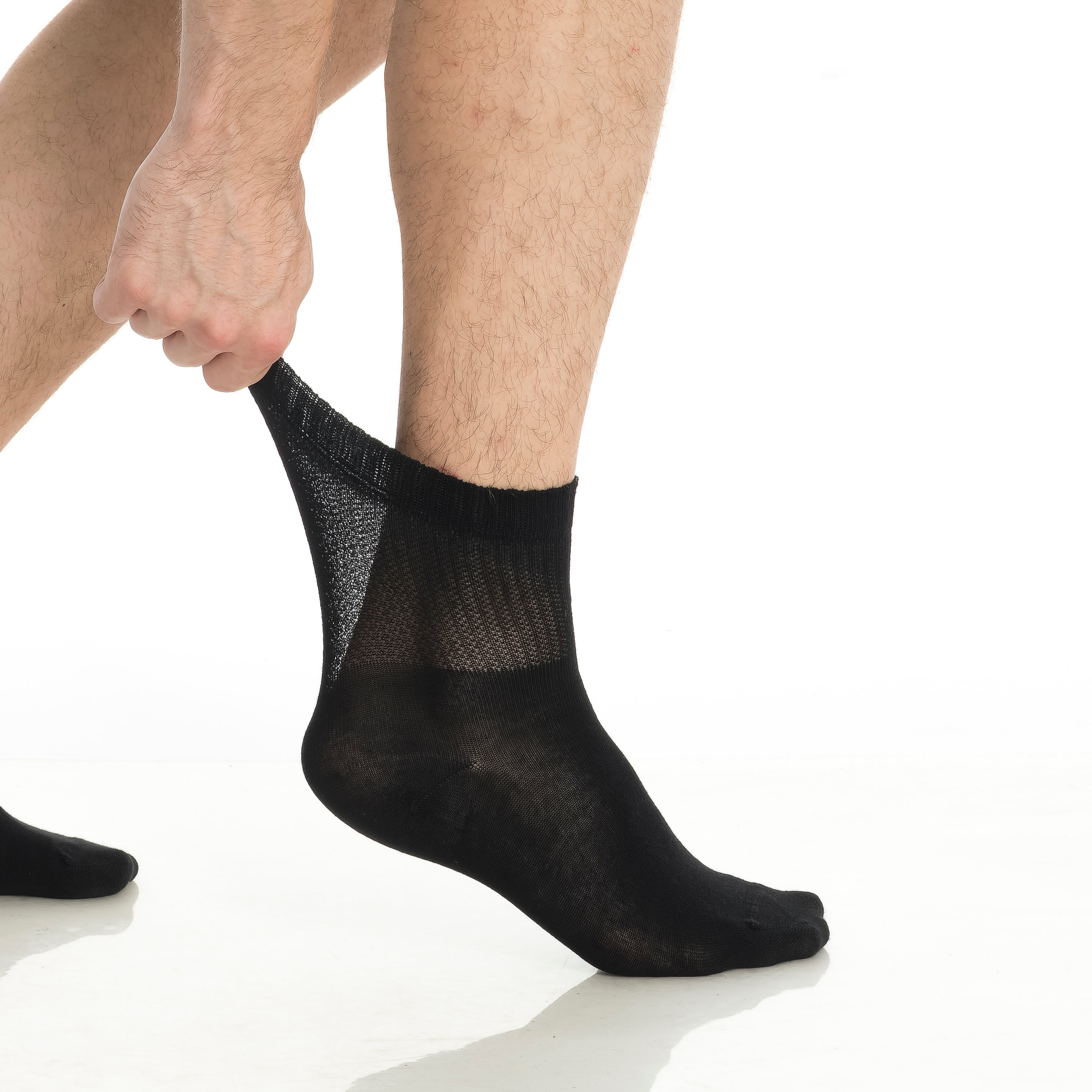 Black bamboo diabetic ankle socks, one sock being pulled on with breathable panel.