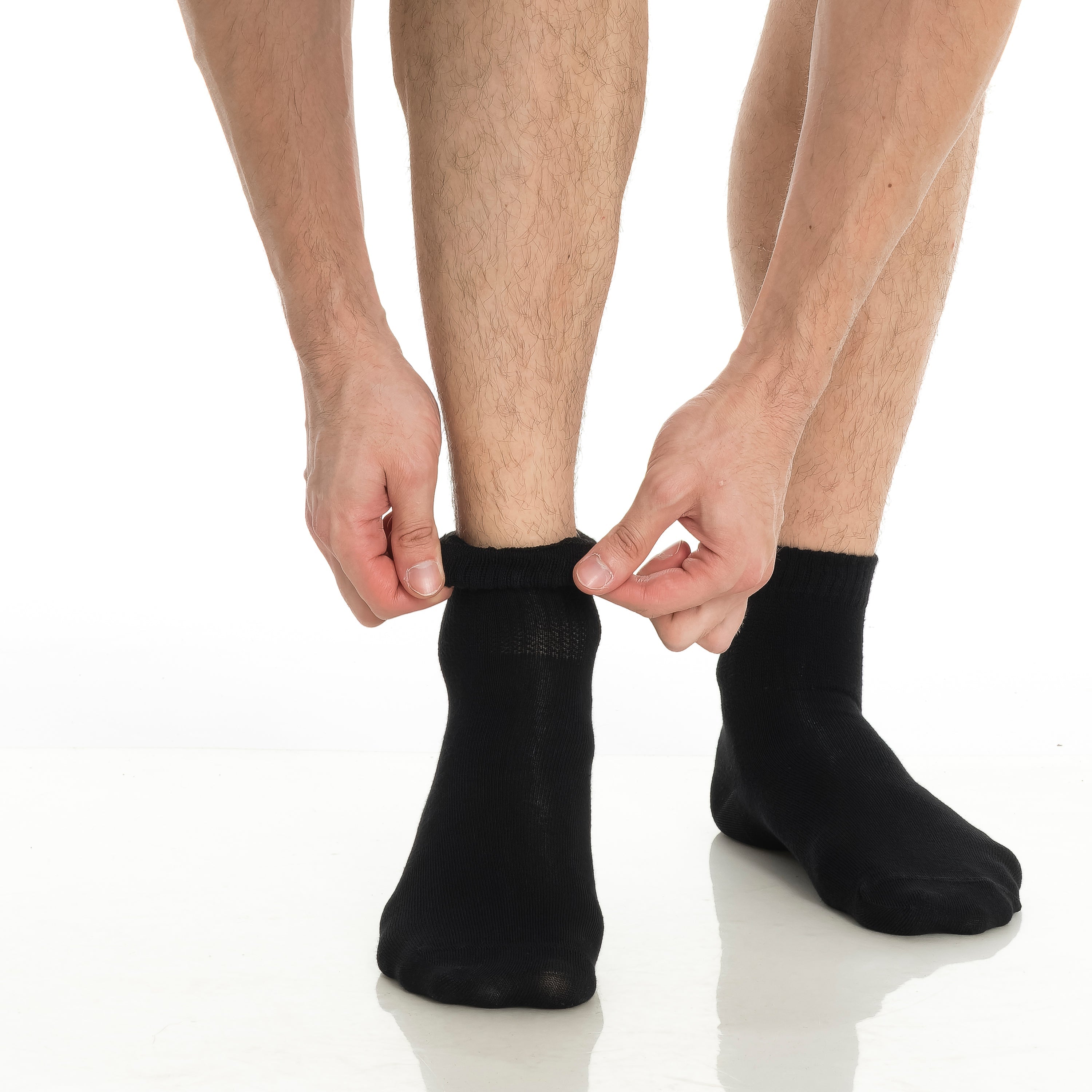 Black bamboo diabetic ankle socks, pair being pulled on, crew cuff.