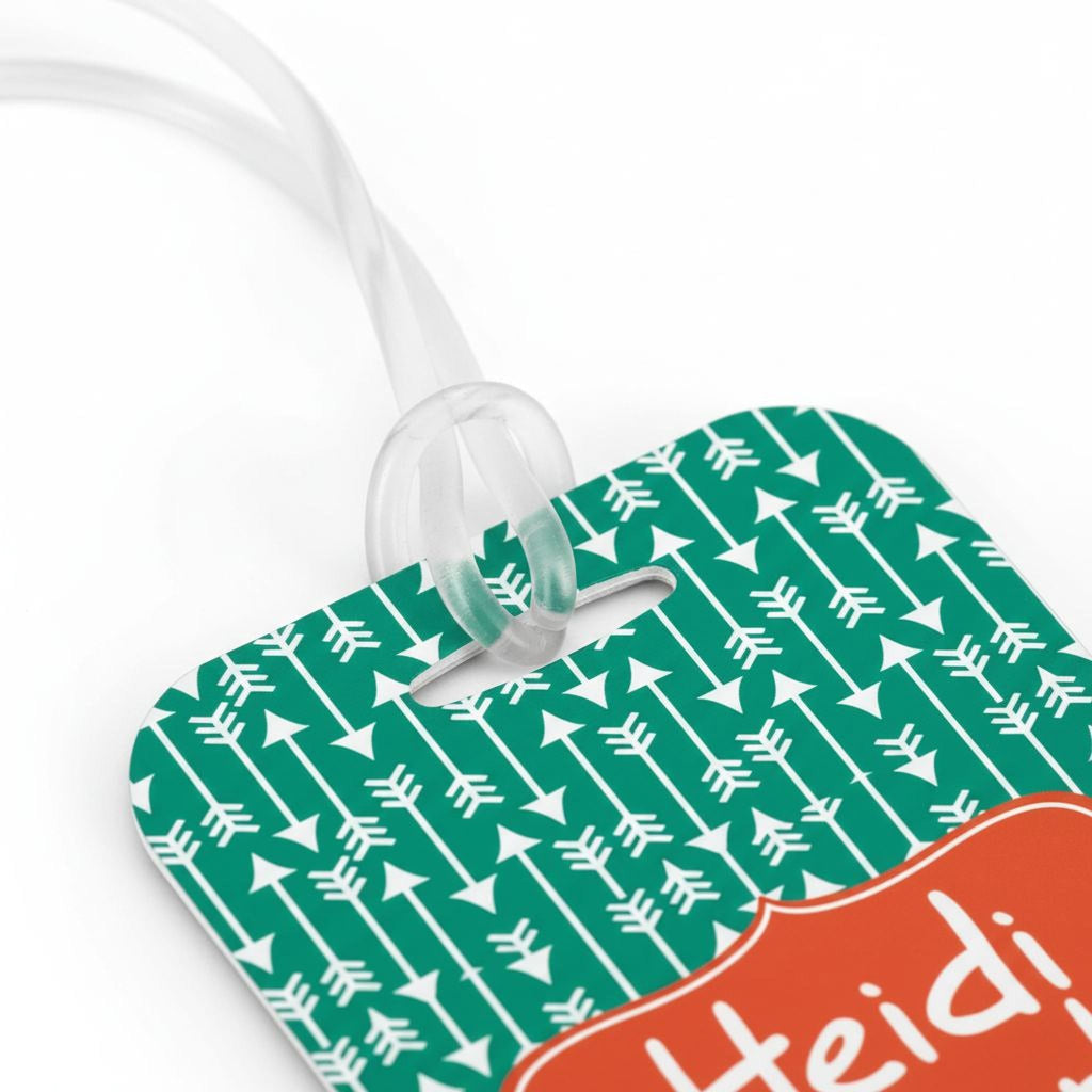 Green patterned bag tag close-up with white icon lines and orange name label