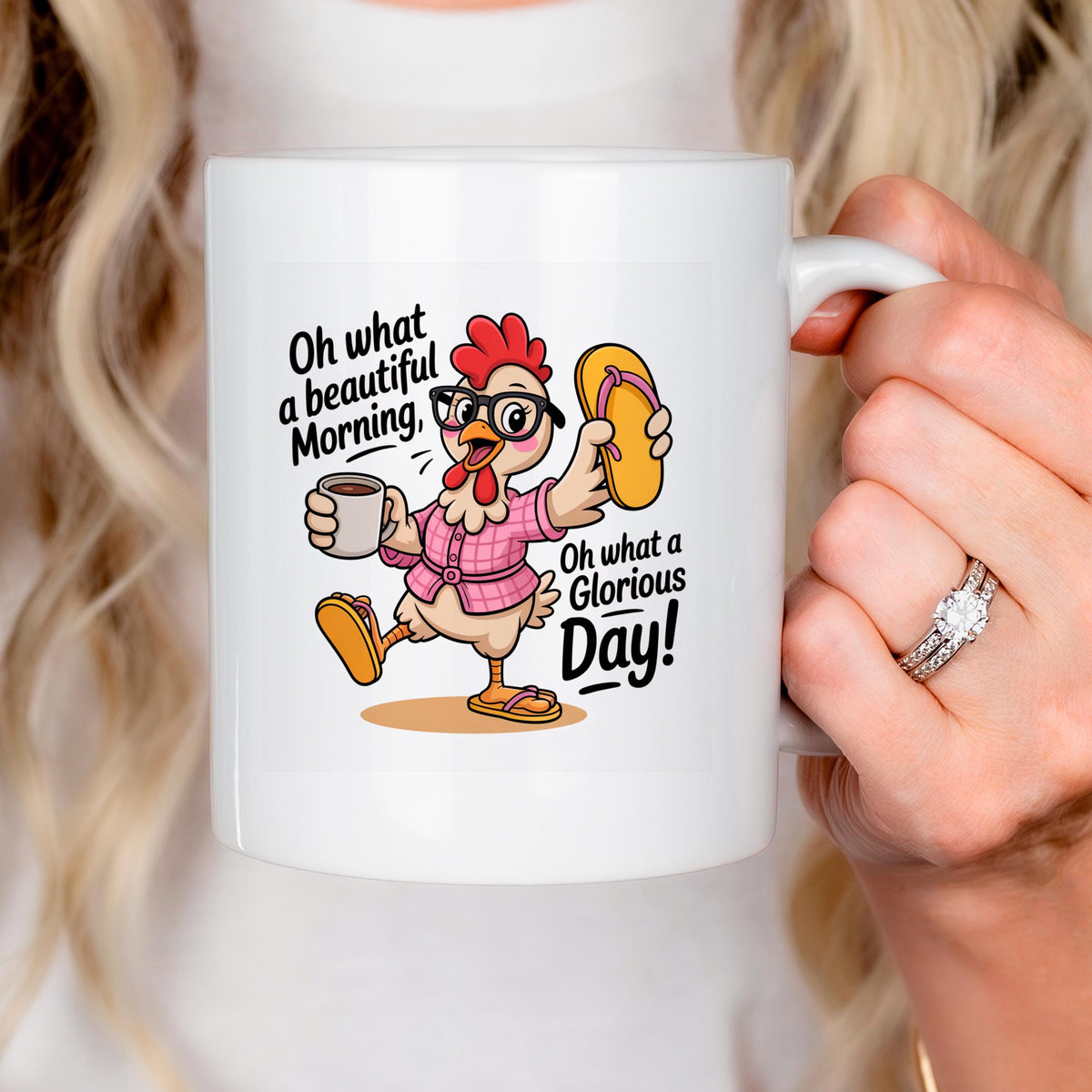 White ceramic mug with chicken graphic, held by a person with visible ring and nails