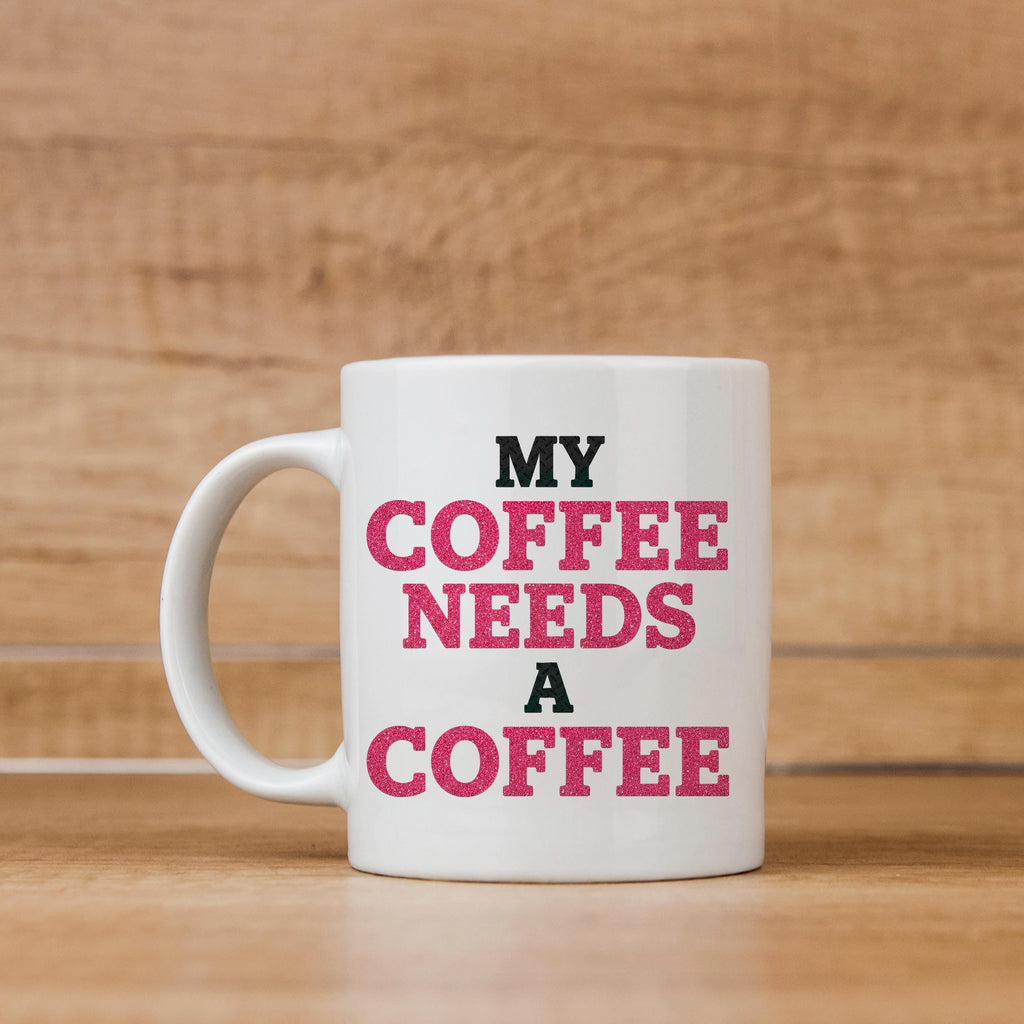 White ceramic coffee mug with "MY COFFEE NEEDS A COFFEE" pink and black text