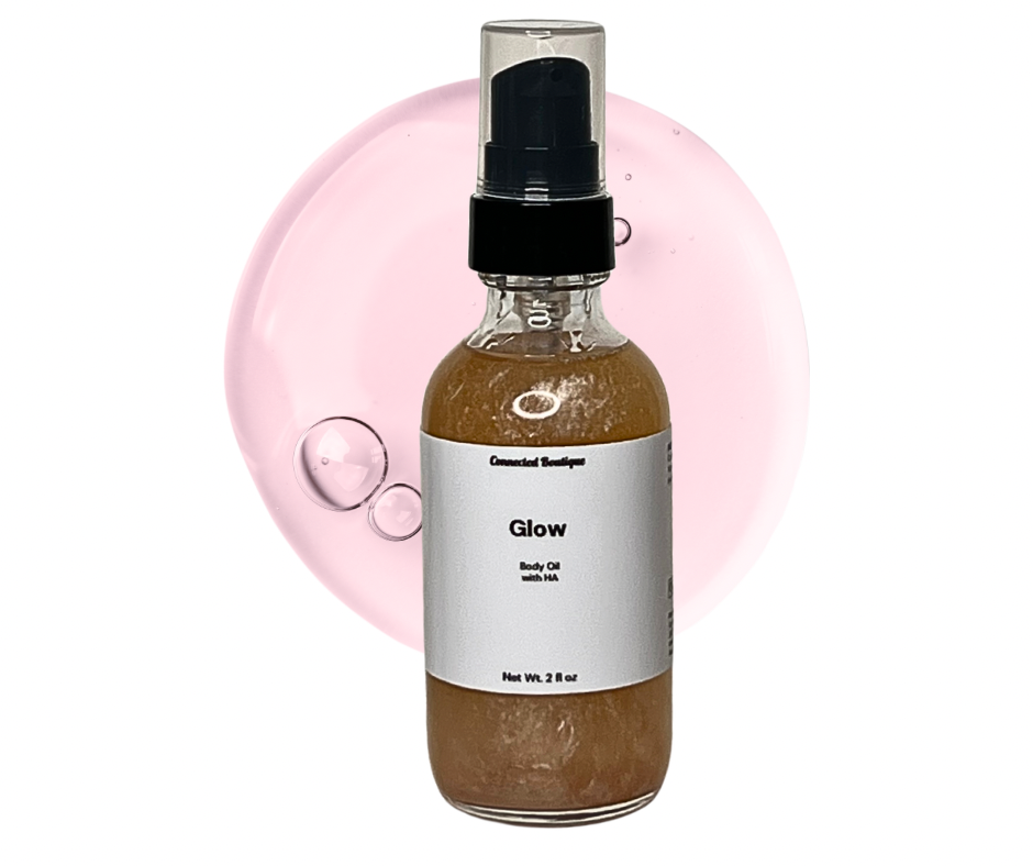 Glow body oil spray bottle, clear glass with black pump, medium brown oil liquid