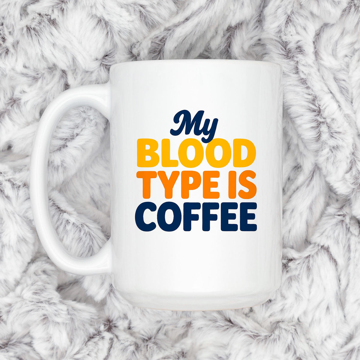 White ceramic coffee mug with handle, “My BLOOD TYPE IS COFFEE” on the side.