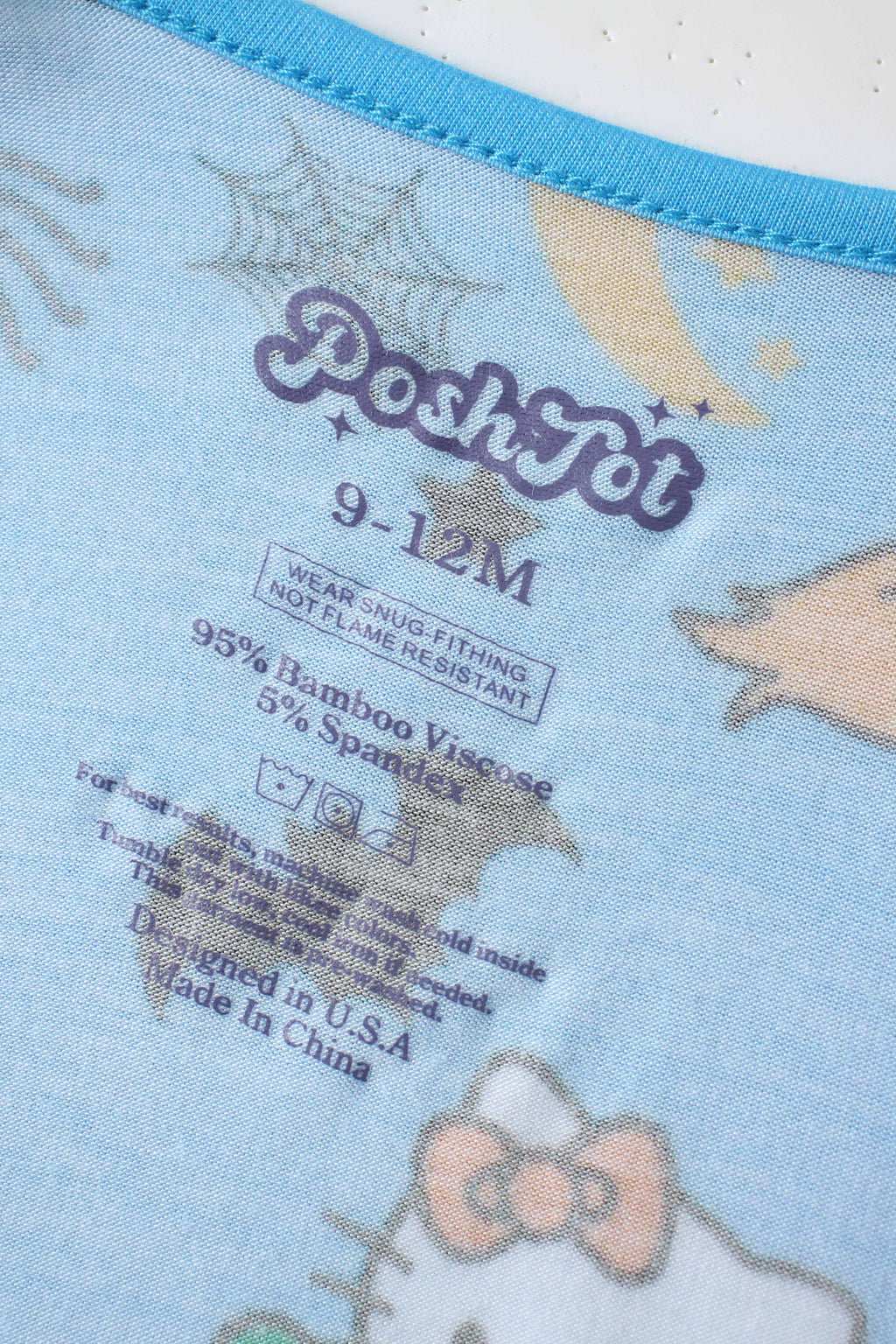 PoshTOT inner neck label on blue baby bamboo romper with stars and cat print