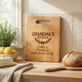 Light wood cutting board with carrying handle and engraved “GRANDMA’S KITCHEN”