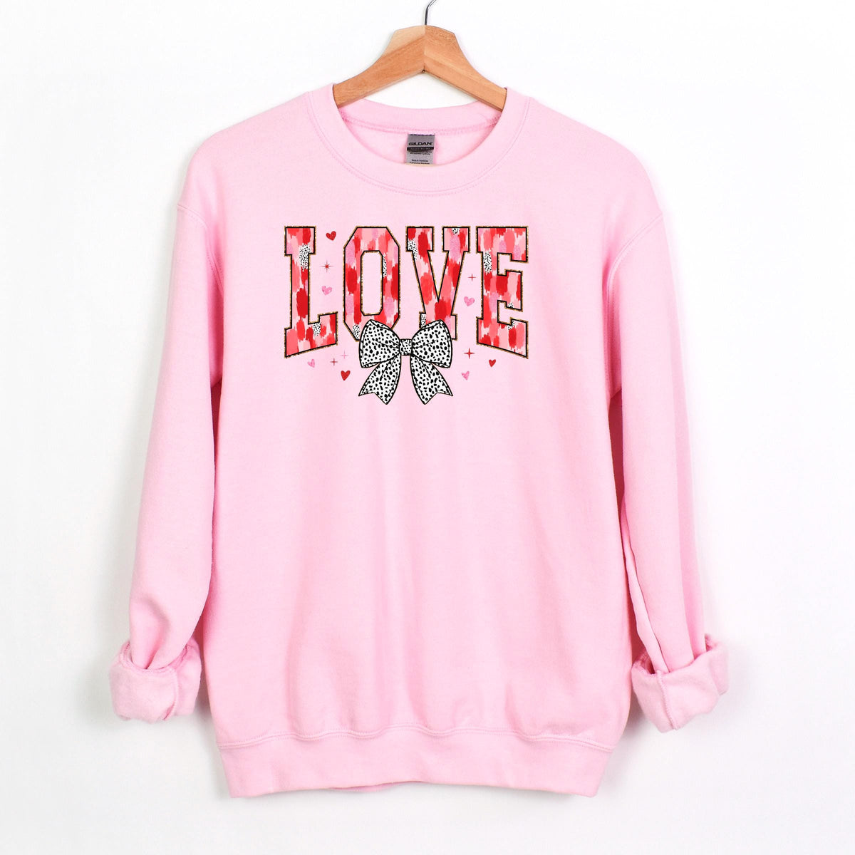 Light pink crewneck sweatshirt with LOVE graphic and black polka-dot bow