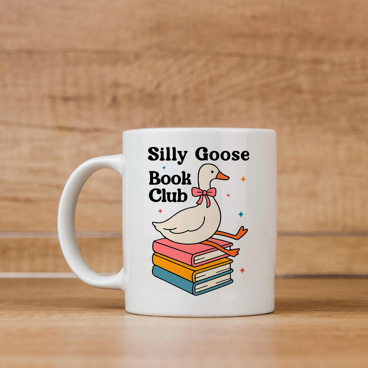 White ceramic mug with goose and stacked books graphic, 'Silly Goose Book Club' text.