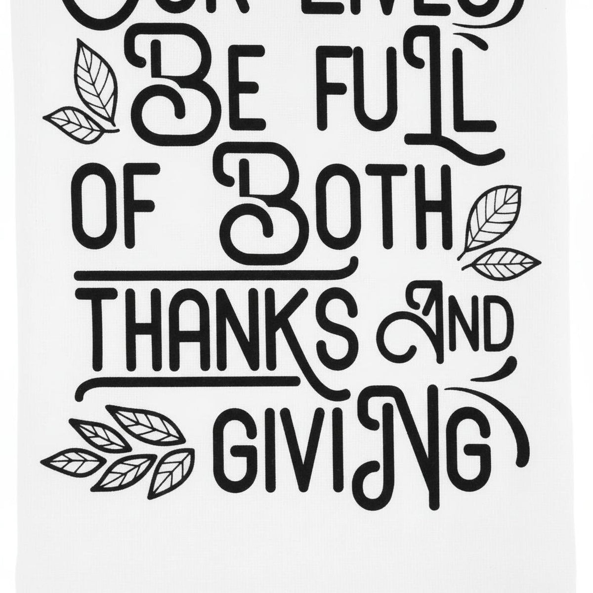 Close-up Thanksgiving kitchen towel with black quote and leaf accents on white fabric