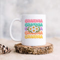 White ceramic coffee mug with Grandma text and colorful daisy floral design