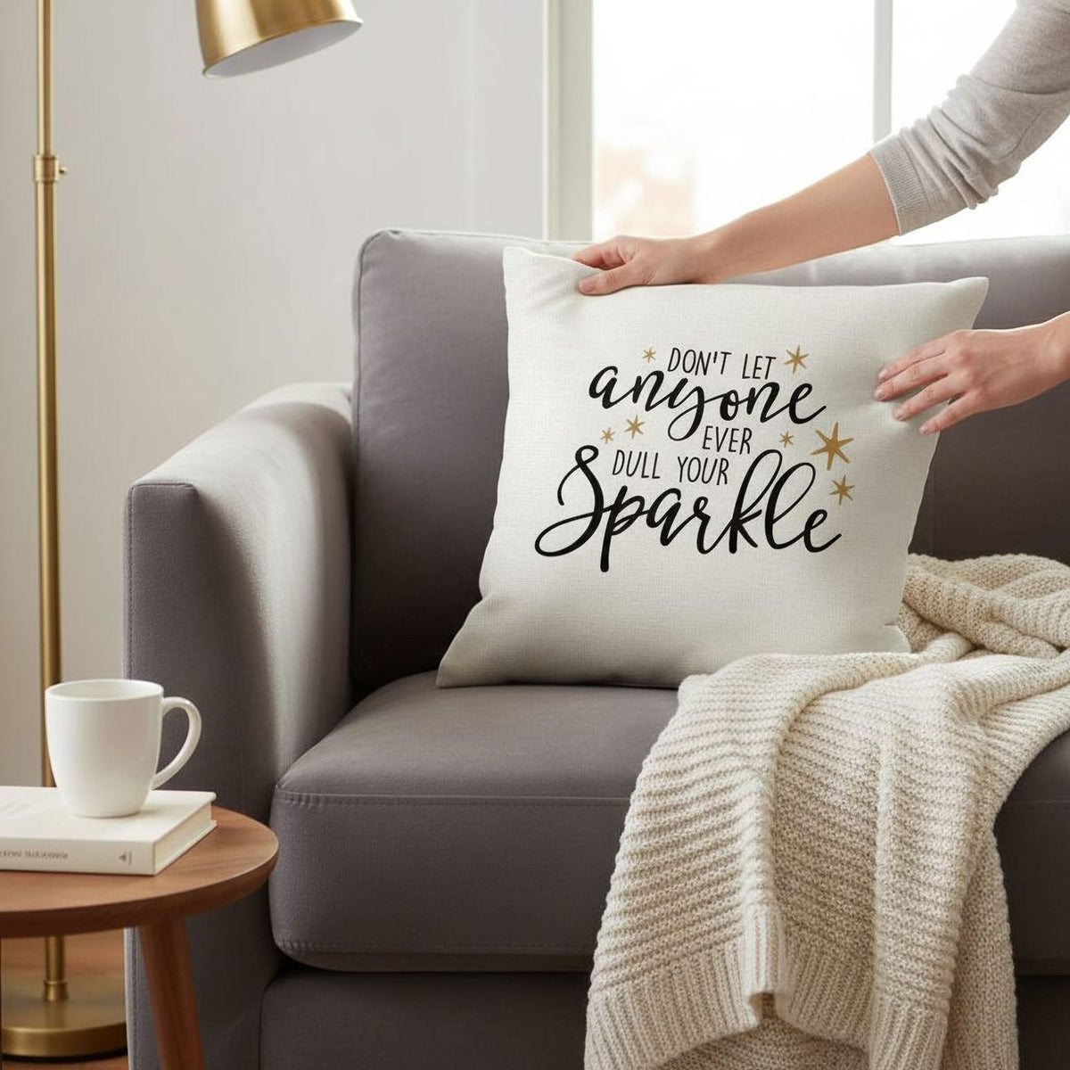 White motivational pillow cover with black script and gold stars, 'Don't let anyone sparkle'