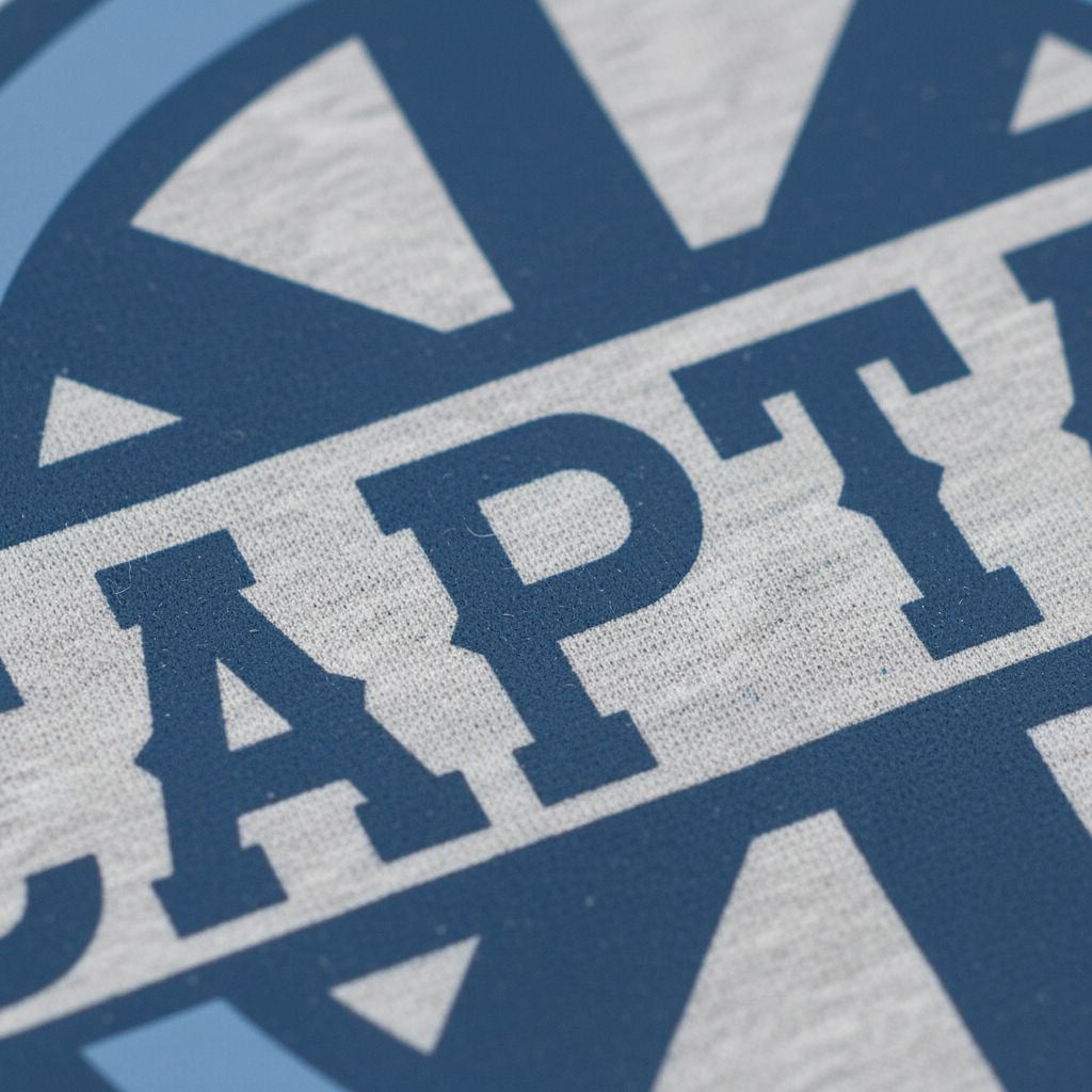 Close-up of blue CAPTAIN text on gray T-shirt fabric