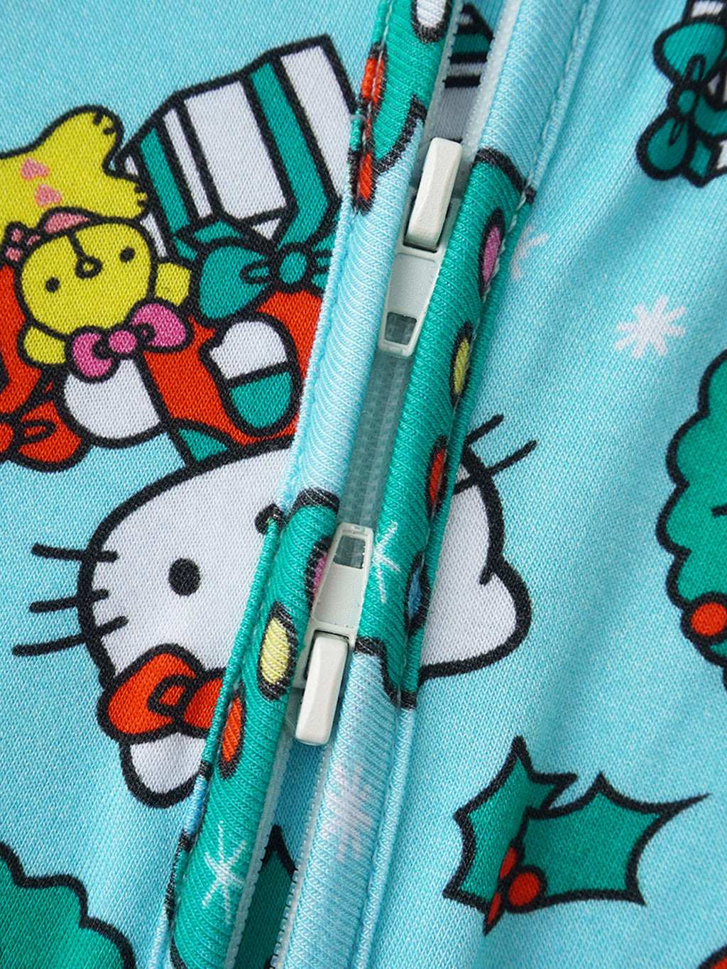 Baby romper zipper close-up on light blue fabric with holiday character pattern