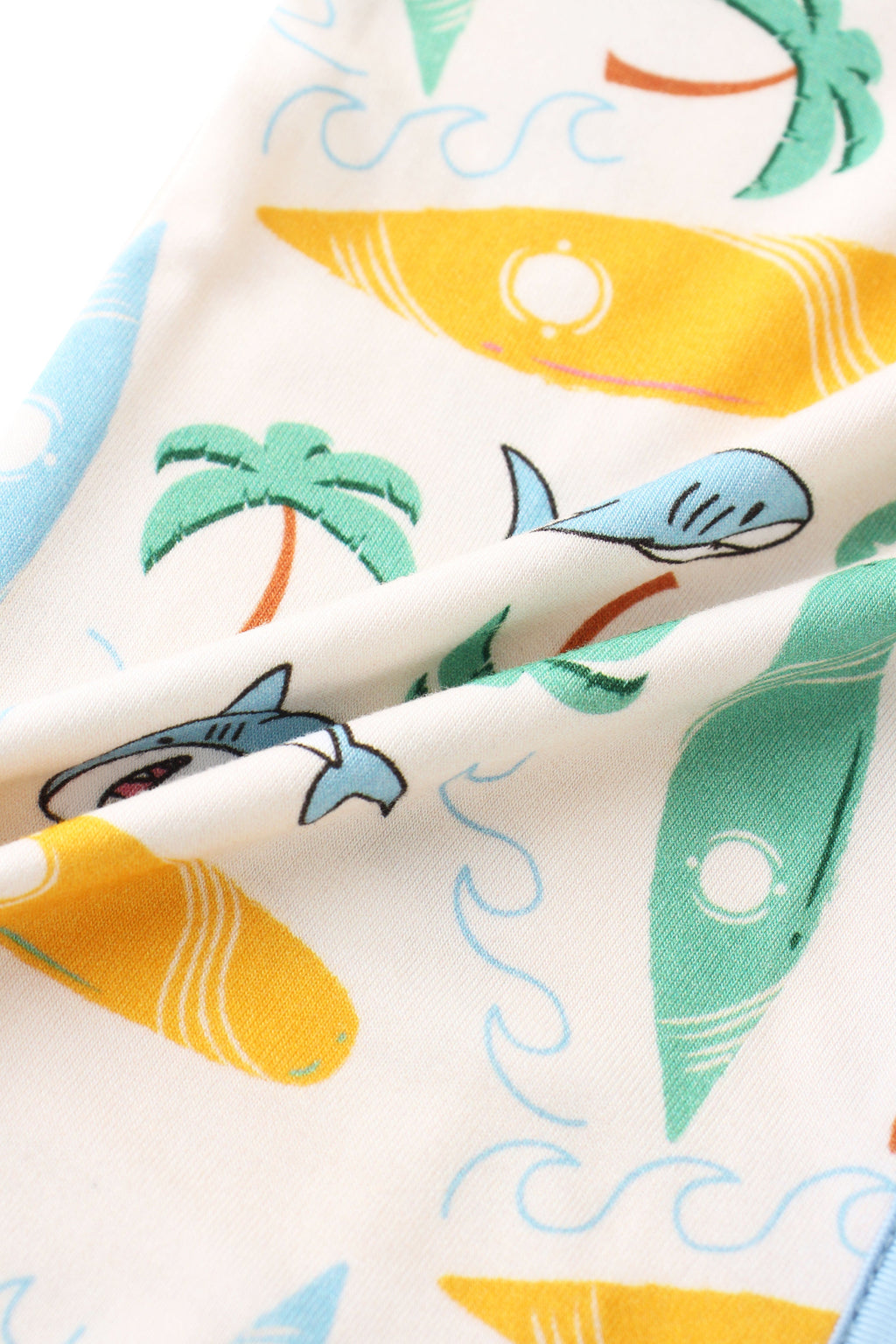 Cream baby romper fabric with dolphins, surfboards, waves, and green palms