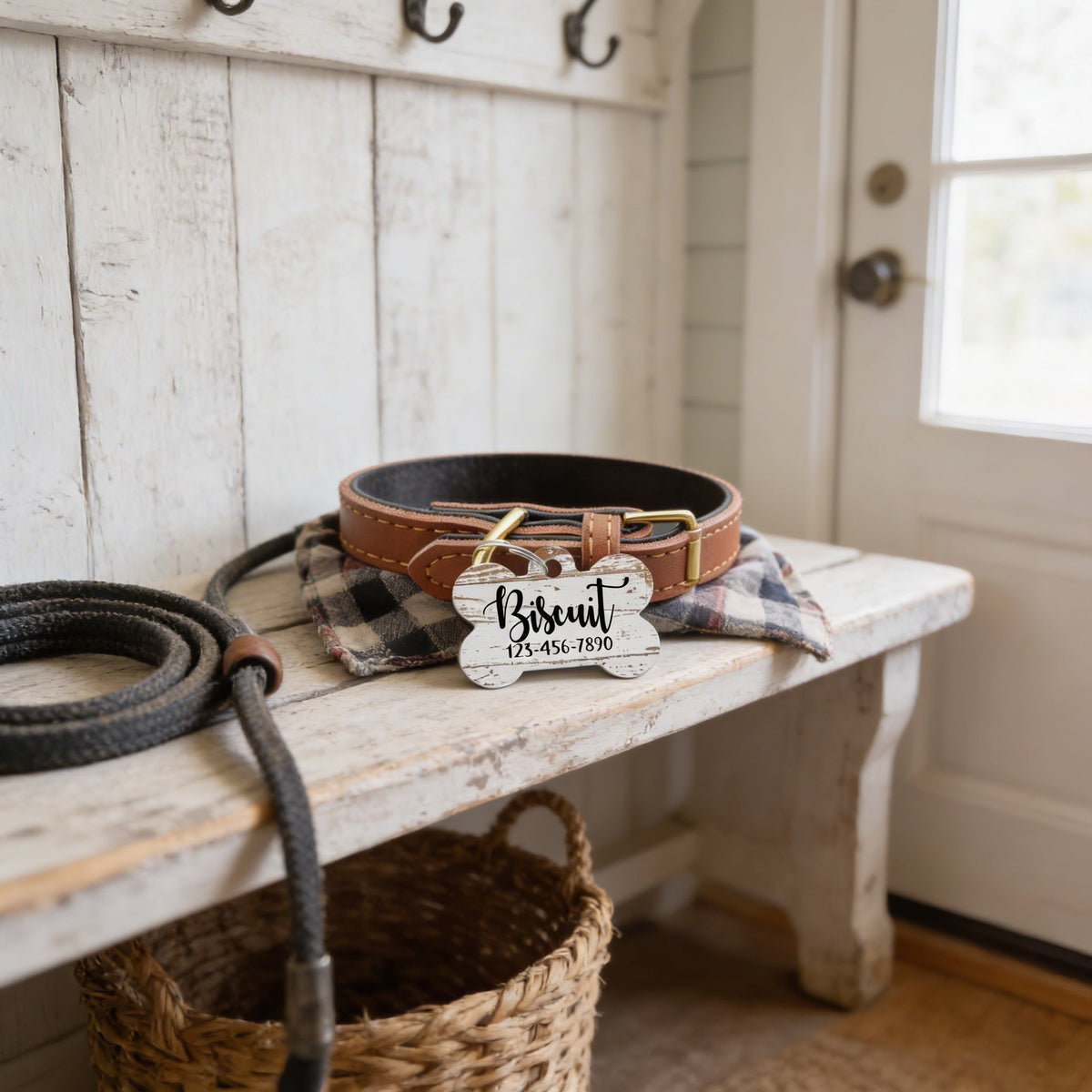 Pet ID tag on brown dog collar near a wooden bench, wood-pattern Bisquit engraving