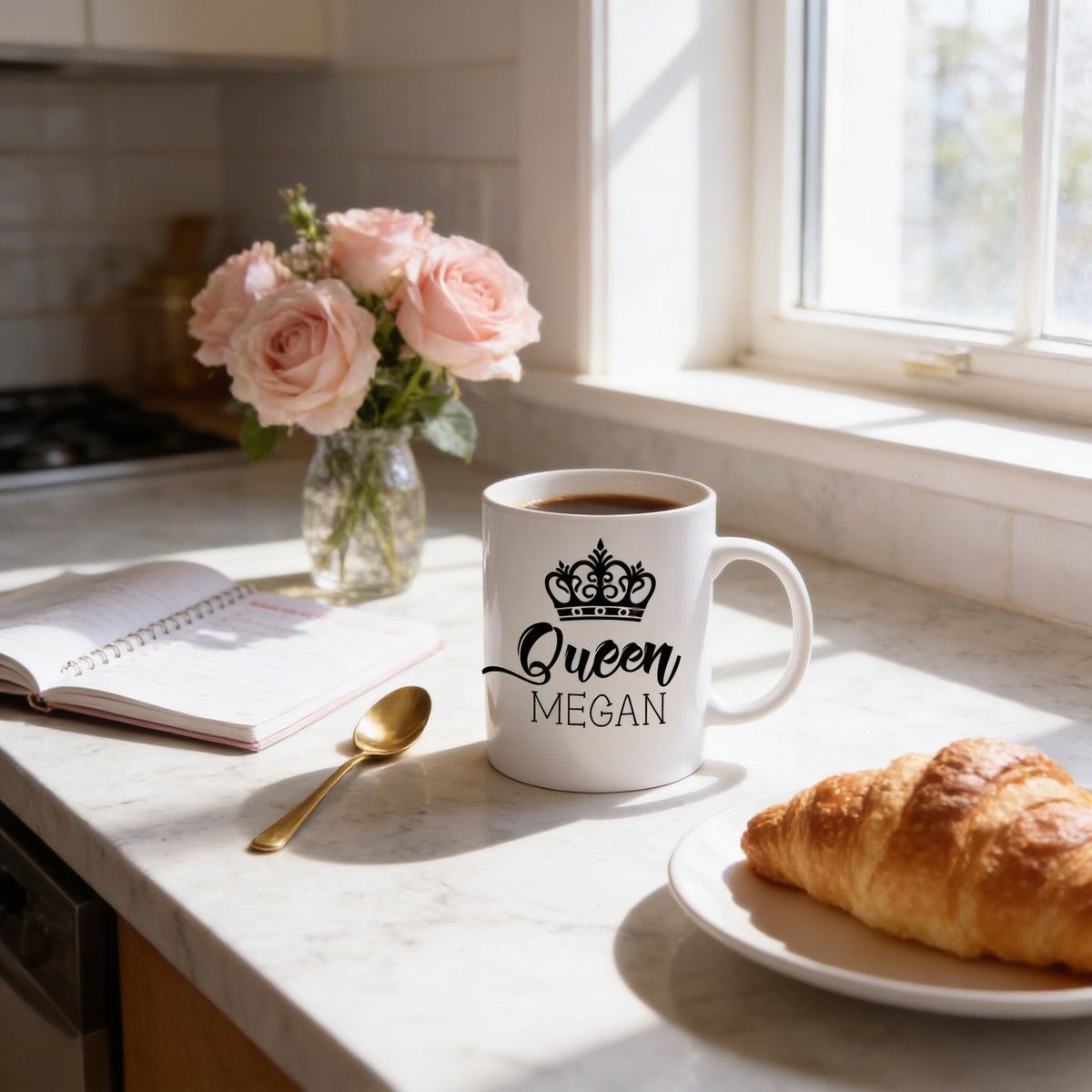 White personalized coffee mug with crown graphic and “Queen MEGAN” text, filled with hot drink.