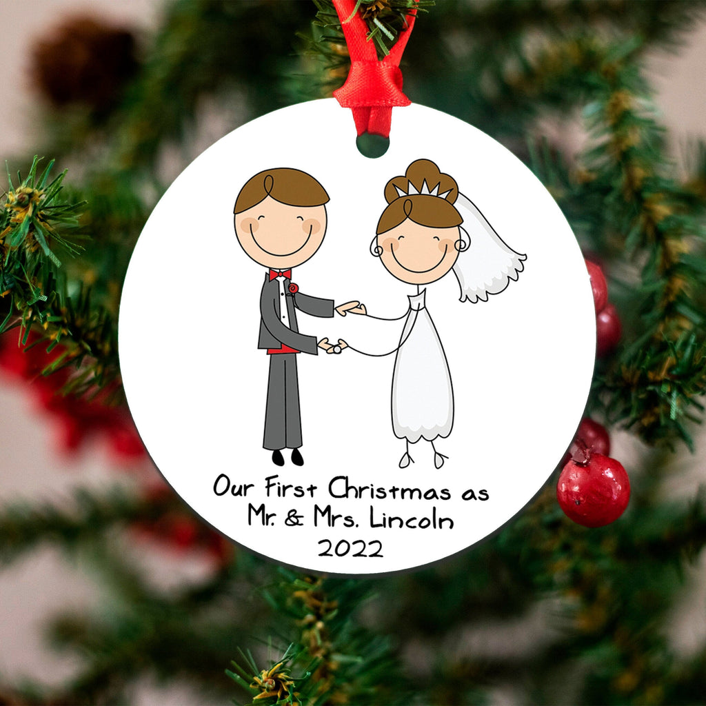 White round wedding ornament on a Christmas tree, red ribbon, illustrated couple and '2022' text