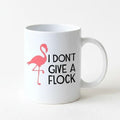 White ceramic coffee mug with pink flamingo and 'I DON'T GIVE A FLOCK' print