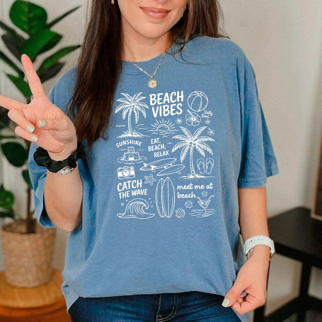 Blue women’s T-shirt with light blue “Beach Vibes” beach graphic on the front