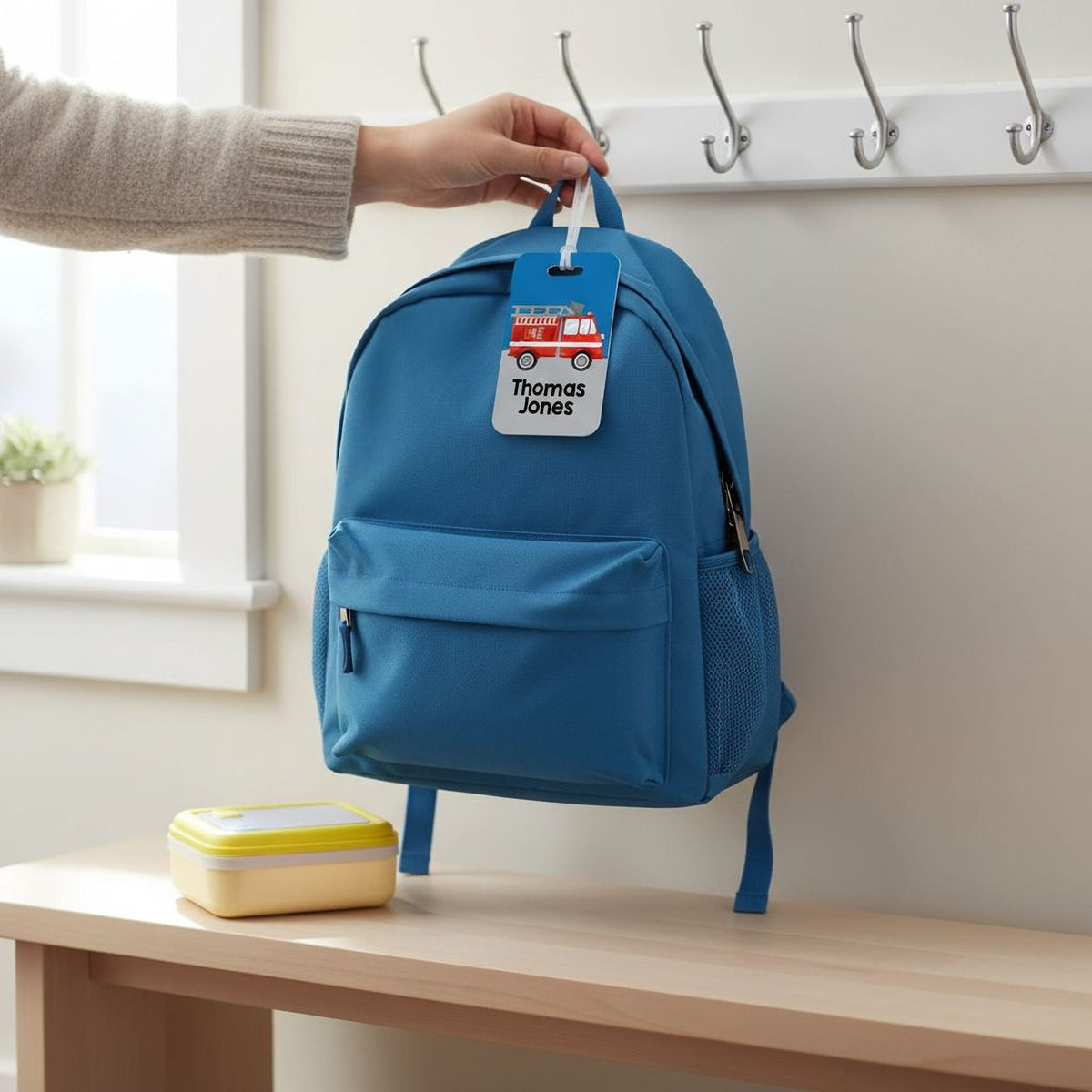 Blue boys backpack with fire truck name tag attached to the front pocket