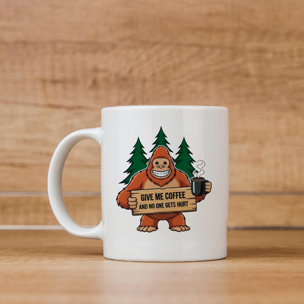 White ceramic coffee mug with Bigfoot graphic holding sign and steaming cup.
