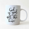 White ceramic coffee mug with 'God is good all the time' script on front