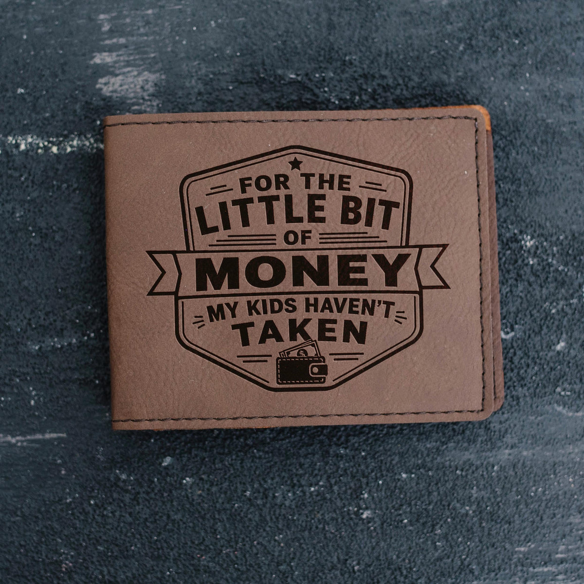 Slim brown leather bifold wallet with engraved front badge and stitched edges