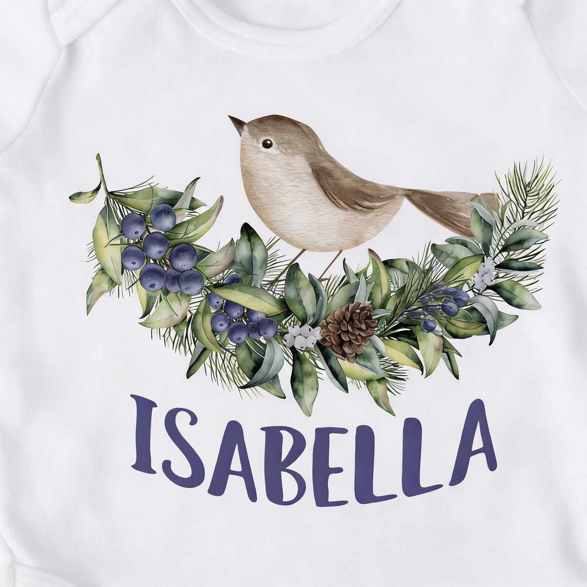 White baby bodysuit close-up: woodland bird with blue-violet floral wreath and 'ISABELLA'