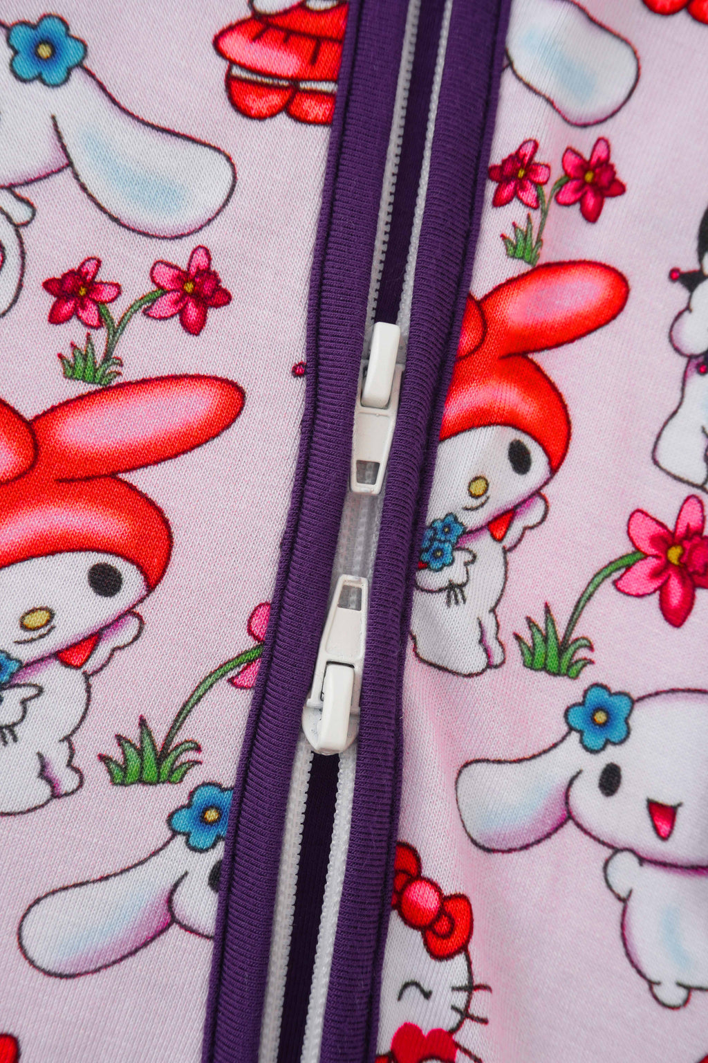 Baby romper front zipper in purple with character print fabric close-up