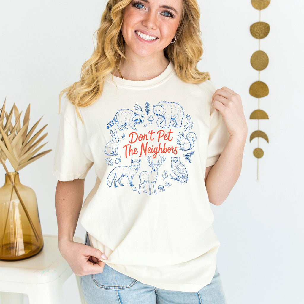 Ivory crewneck T-shirt featuring blue woodcut-style animal 'Don't Pet The Neighbors' print