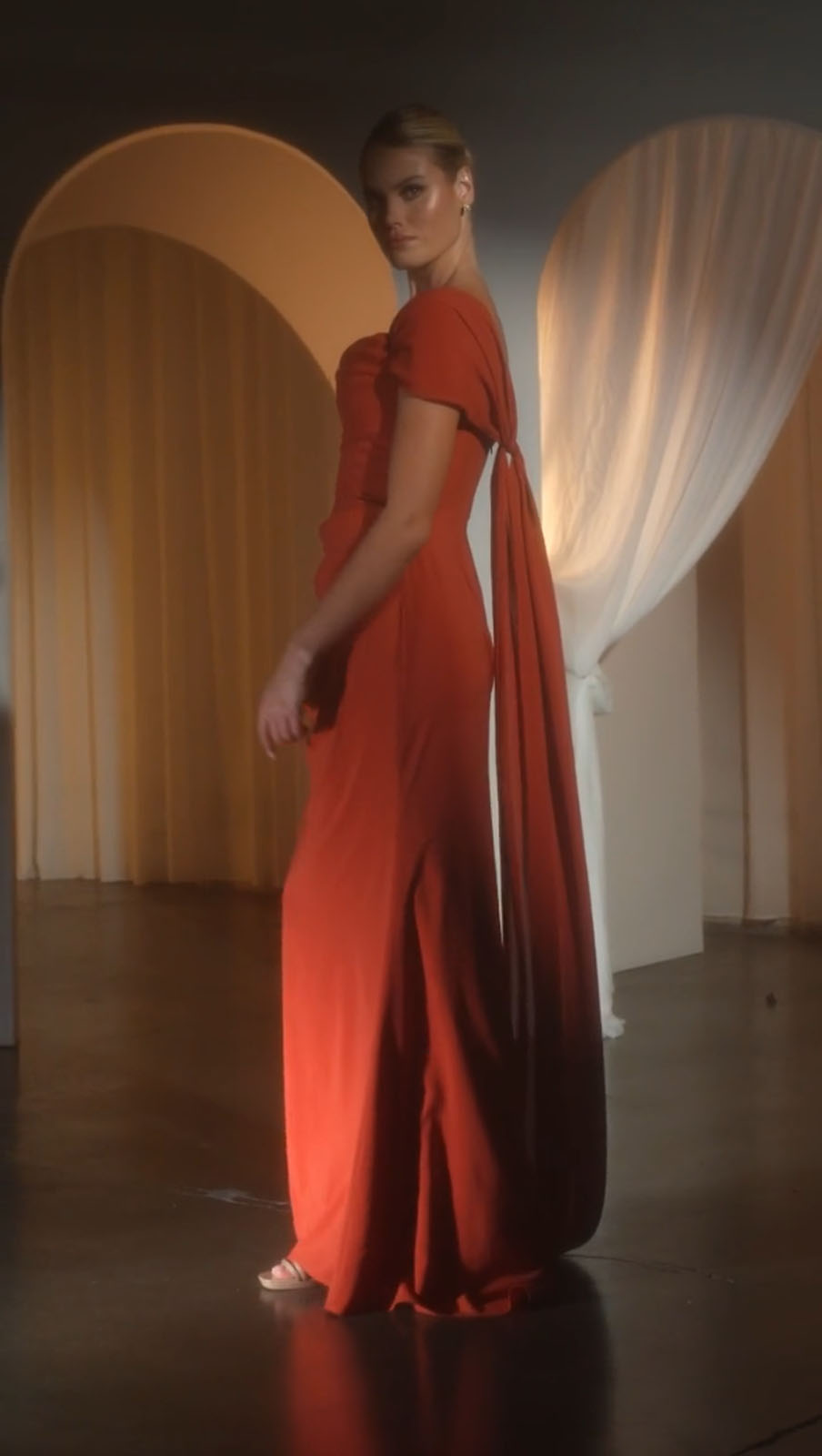 Sienna red draped evening dress with open back and long flowing skirt