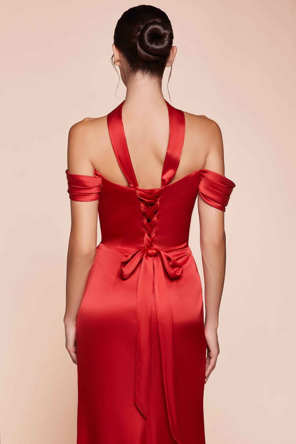 Satin off-shoulder red gown with draped bodice and tied bow detail at waist