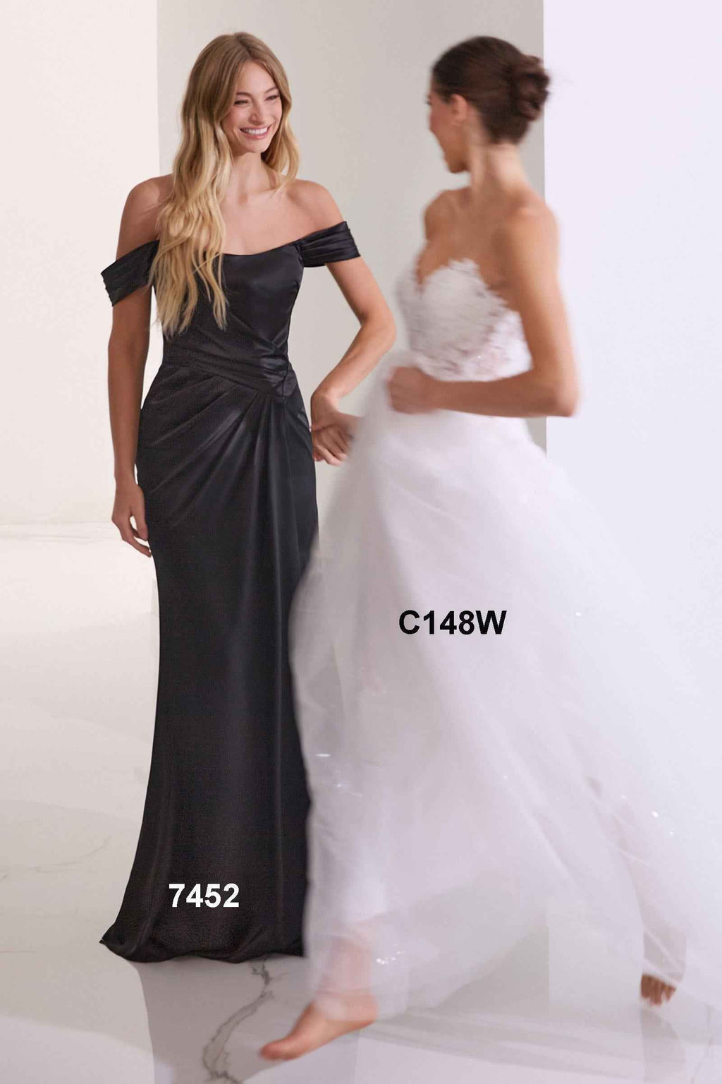 Off-shoulder black satin gown with ruched waist and long skirt with front slit.