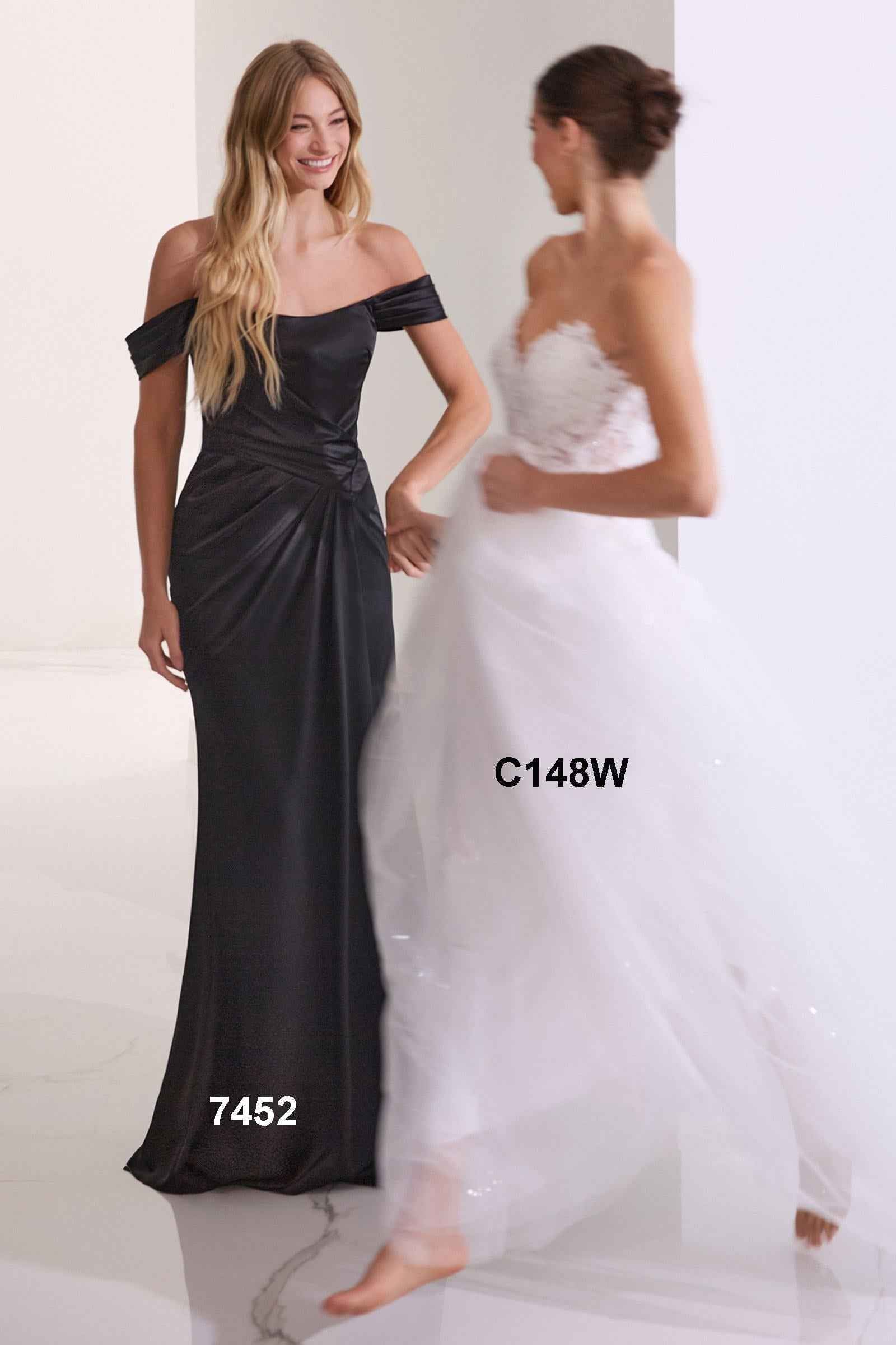 Off-shoulder black satin gown with ruched waist and long skirt with front slit.