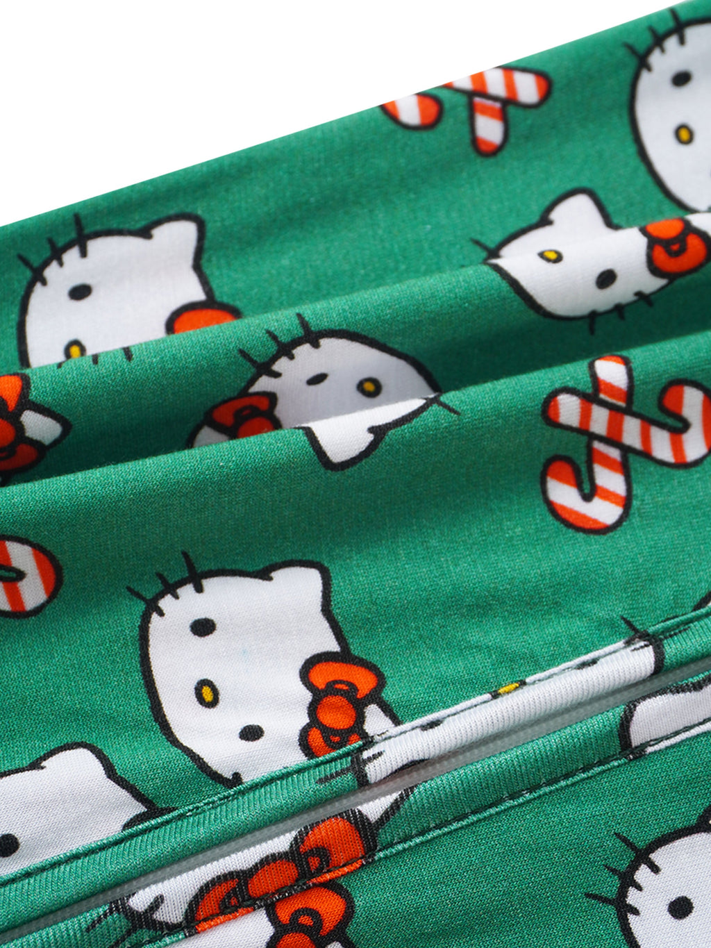 Green baby romper fabric close-up with Hello Kitty faces and peppermint striped details