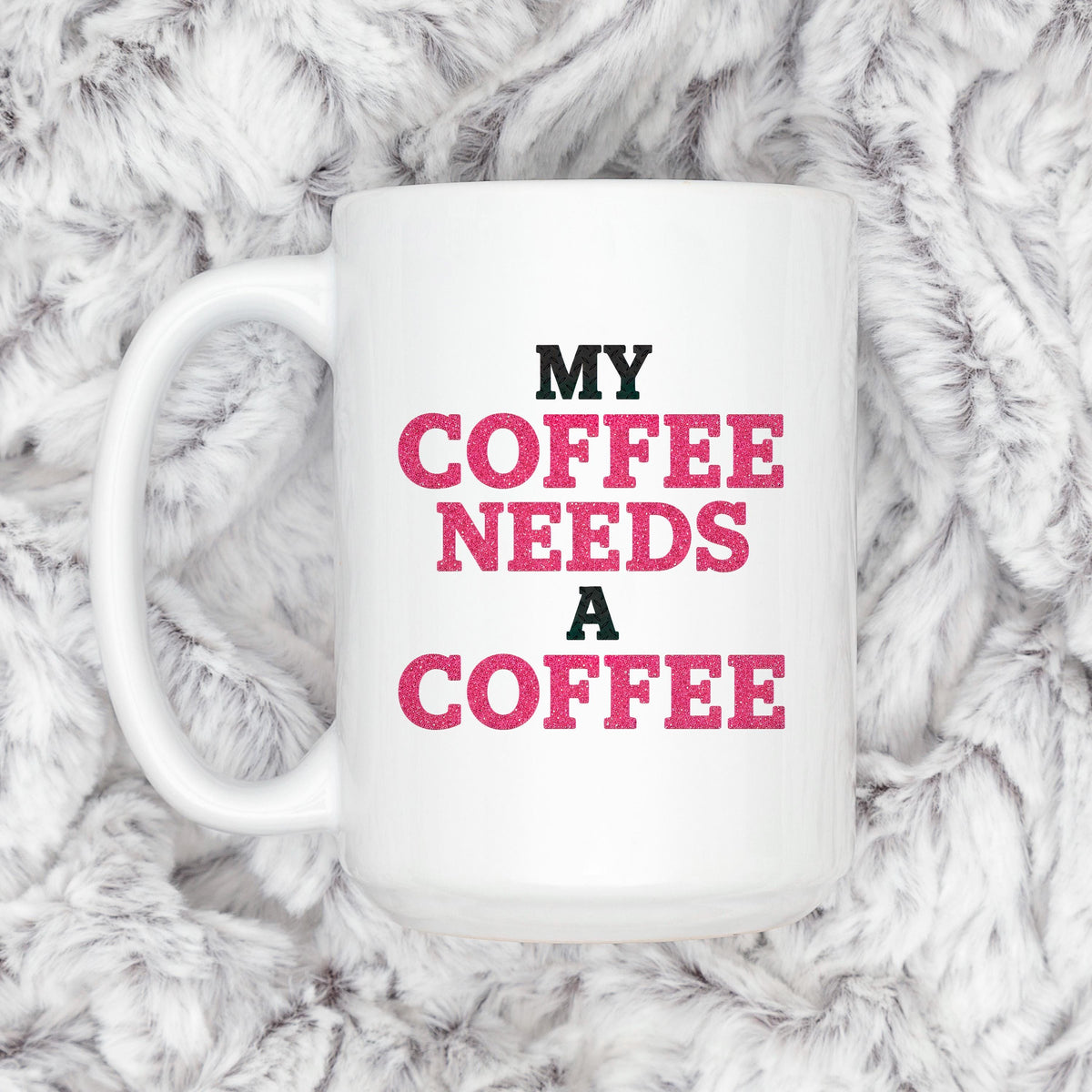 White ceramic coffee mug with "MY COFFEE NEEDS A COFFEE" slogan, close-up