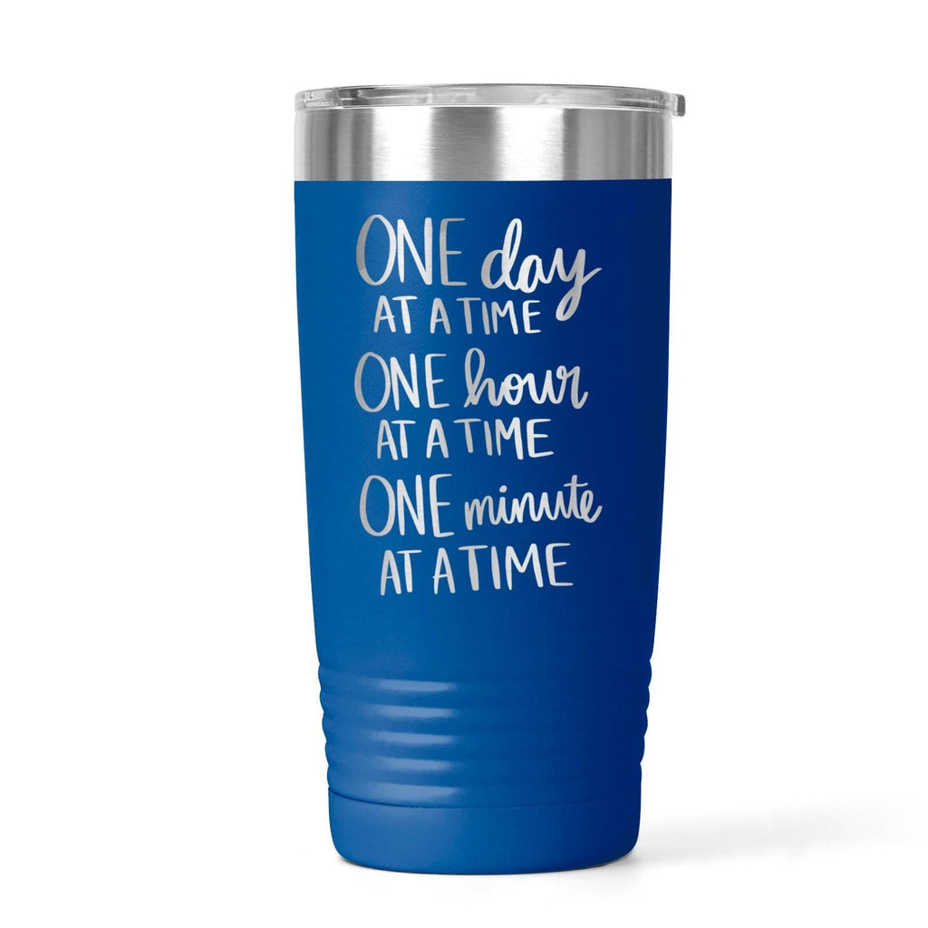 Blue stainless steel tumbler with “One day at a time” motivational text